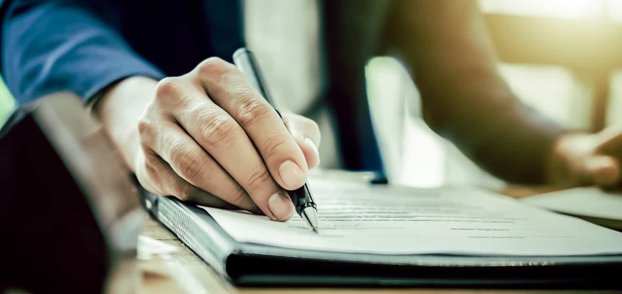 Person reviewing sheet with pen.