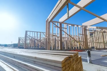 Wooden framework of a house under construction against blue sky